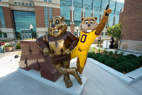 Goldy the mascot posing with the statue of Goldy pointing to sky 
